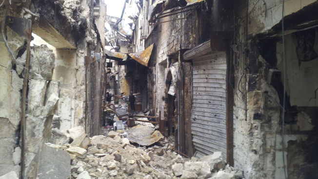 Residents_stand_amidst_debris_in_the_old_city_of_Aleppo.jpg